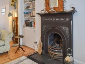 a living room with a black fireplace in a room at Blue Cottage in Broadstairs