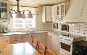 een keuken met witte kasten, een wastafel en een fornuis bij Stunning Home In Mrbylnga With 3 Bedrooms And Wifi in Mörbylånga