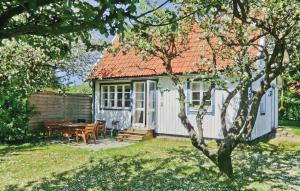 een klein wit huisje met een tafel in de tuin bij Stunning Home In Mrbylnga With 3 Bedrooms And Wifi in Mörbylånga
