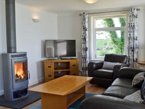 a living room with a fireplace and a tv at Yonderton Mcgill Cottage - Uk11182 in Hollybush