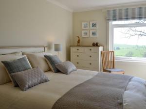 a bedroom with a bed with a dresser and a window at Yonderton Mcgill Cottage - Uk11182 in Hollybush