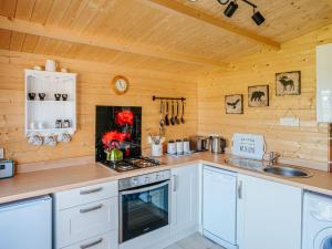 a kitchen with white cabinets and a stove top oven at Nirvana in Stoodleigh