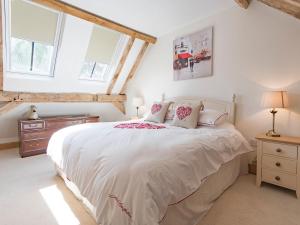 a bedroom with a large bed with white sheets and pillows at Norwood Barn in Maidstone