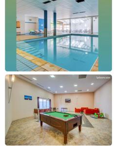 een groot zwembad met een pooltafel in een gebouw bij Au bout du bois Piscine sauna hammam accessible en saison et le logement accessible toute l annee in Les Déserts
