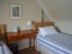 a bedroom with a bed and a desk with a lamp at Roadstead in Fowey