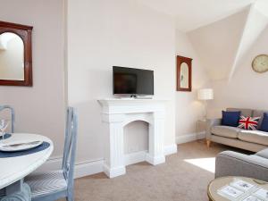 a living room with a fireplace with a tv over it at Skyfall in Canterbury