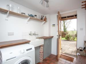 a laundry room with a washer and dryer at The Old Farmhouse in Chardstock
