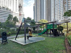 Uma mulher está a brincar num baloiço num parque. em Flair Towers STUDIO ROOMS Staycation em Manila