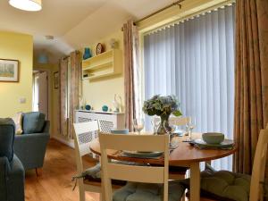 a dining room and living room with a table and chairs at The Annexe in Barham