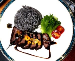 a plate of food with meat and broccoli on it at Blue Suites Hanamuro in Zamami