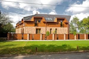 een houten huis met een hek ervoor bij Airport Wellness Panzio in Hajdúszoboszló