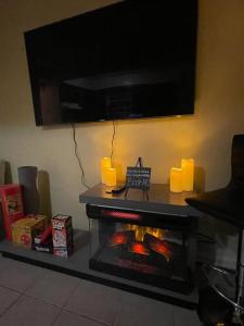 sala de estar con chimenea y TV encima. en Enhanced 2Bedroom, en Williams Bridge