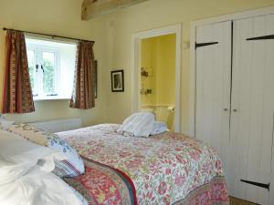 1 dormitorio con cama y ventana en The Old Forge, en Cattistock