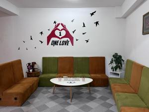 uma sala de espera com um sofá, uma mesa e pássaros em One Love em Sarajevo