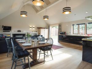 a kitchen and living room with a wooden table and chairs at Station Lodge in Stretton on Fosse