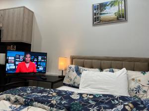 1 dormitorio con 1 cama y escritorio con TV en Belvue Serviced Apartment - Ealing Broadway, en Ealing
