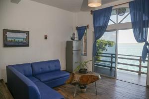a living room with a blue couch and a table at Seven Blue House Village & Lodge in Bacalar