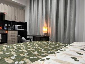 a bedroom with a bed with a green and white blanket at Belvue Serviced Apartment - Ealing Broadway in Ealing