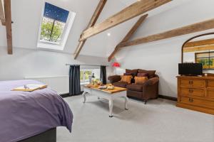 a bedroom with a bed and a couch and a table at The Coach House in Blaenporth