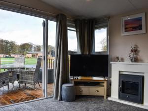 a living room with a television and a fireplace at Doodles At Brid in Sewerby