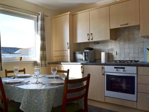 印威內斯的住宿－Ness-side Apartment，一间带桌椅的厨房和一间带桌子的厨房