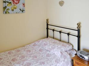 a bedroom with a bed with a flowered comforter at Beckside in Bellerby