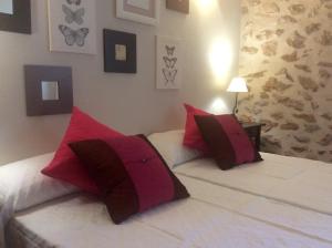 テウラーダにあるCasa San Miquel - BTBのベッドルーム1室(ベッド2台、赤と白の枕付)