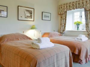 two beds in a bedroom with towels on them at The Dovecote in Birstwith