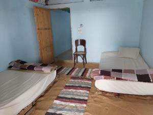 a room with two beds and a chair in it at ارجوندي جيست هاوس in Aswan