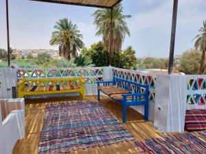 a porch with two benches and rugs at ارجوندي جيست هاوس in Aswan