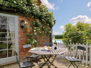 a wooden table and chairs on a patio at Prospect Cottage in Wittersham
