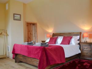 a bedroom with a large bed with red pillows at Loch Long View in Sallachy