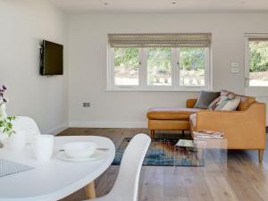 a living room with a couch and a table at Swallows Nest in Bibury