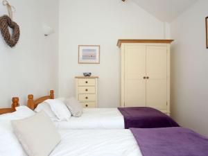 a bedroom with two beds and a cabinet at Primrose in Shepton Mallet