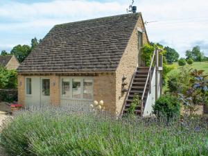 ein kleines Backsteinhaus mit einer Treppe im Garten in der Unterkunft Swallows Nest in Bibury