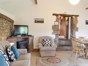 a living room with a fireplace and a tv at Woodland View-uk11826 in Llandefaelogfâch