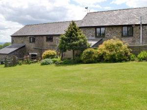 une ancienne maison en pierre avec une grande cour dans l'établissement Woodland View-uk11826, à Llandefaelogfâch