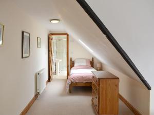 1 dormitorio con 1 cama y vestidor en el ático en 2 Sawmill Cottages, en Puncknowle