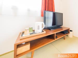 una TV a schermo piatto seduta sopra un tavolo di legno di 波奈 浅草 Hana Asakusa ーSkyTree前駅まで徒歩5分ー a Tokyo