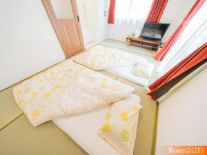 two twin beds in a room with a window at 波奈 浅草 Hana Asakusa ーSkyTree前駅まで徒歩5分ー in Tokyo