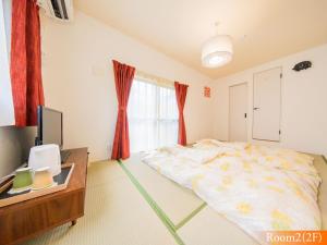 um quarto com uma cama, uma secretária e uma televisão em 波奈 浅草 Hana Asakusa ーSkyTree前駅まで徒歩5分ー em Tóquio