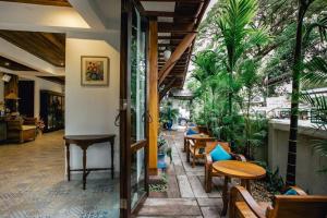 un restaurante con mesas, sillas y palmeras en Gavill15 Classic Boutique House en Chiang Mai