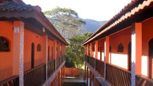 a row of orange buildings with mountains in the background at Suítes Vila Maresias in Maresias