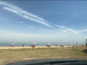 een uitzicht op een strand met parasols en de oceaan bij Chalet Amexico Paradise - Ain Sokhna in Ain Sokhna