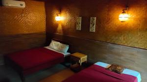 a room with two beds and lights on the wall at Dua Nina 2 Guesthouse in Gili Trawangan