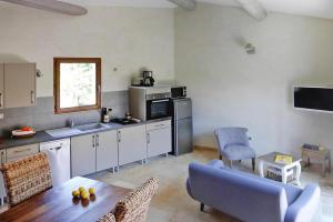 kuchnia ze stołem i niebieskimi krzesłami w pokoju w obiekcie Holiday home with shared pool in Malaucene w mieście Malaucène