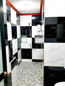 a black and white bathroom with a shower and a toilet at Areeya Phubeach Resort in Ao Nang Beach