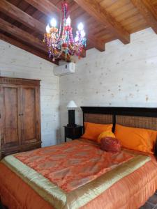 a bedroom with a large bed with a chandelier at Agriturismo Tenuta San Giovanni Casale Leto in SantʼAngelo Muxaro