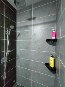 Łazienka z prysznicem wyłożona jest czarnymi kafelkami. w obiekcie Studio in Sunway Onsen @ Lost World of Tambun for 4 w mieście Ipoh