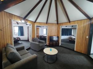 ein Wohnzimmer mit einem Sofa und einem Tisch in der Unterkunft Pure Motel in Rotorua